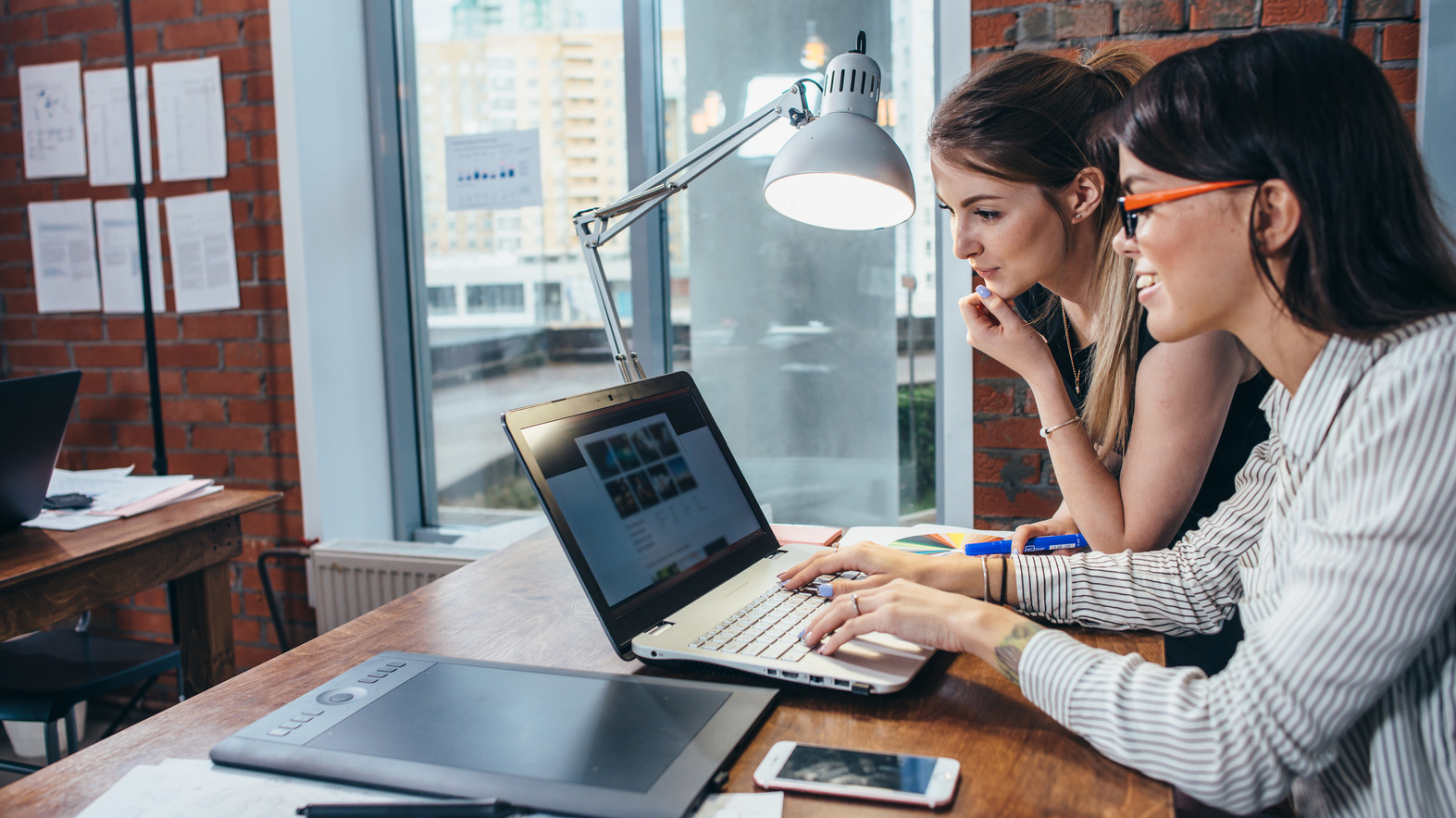 Two female website designers, designing a website